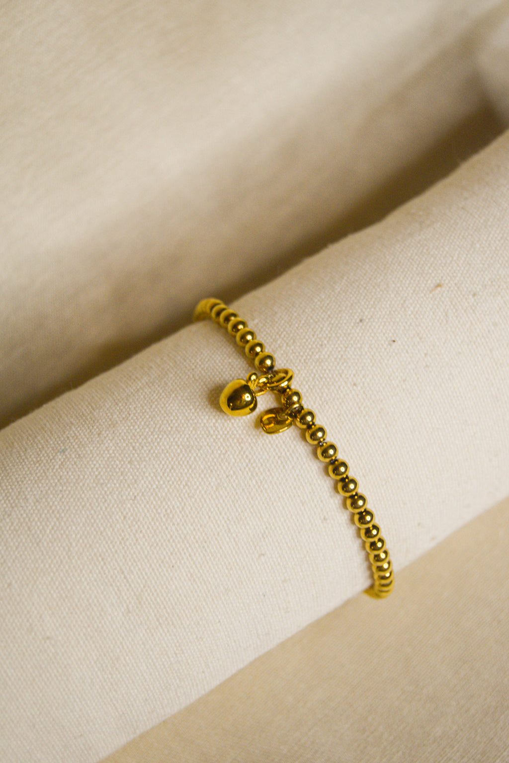 Pulseira dourada pendente maçã