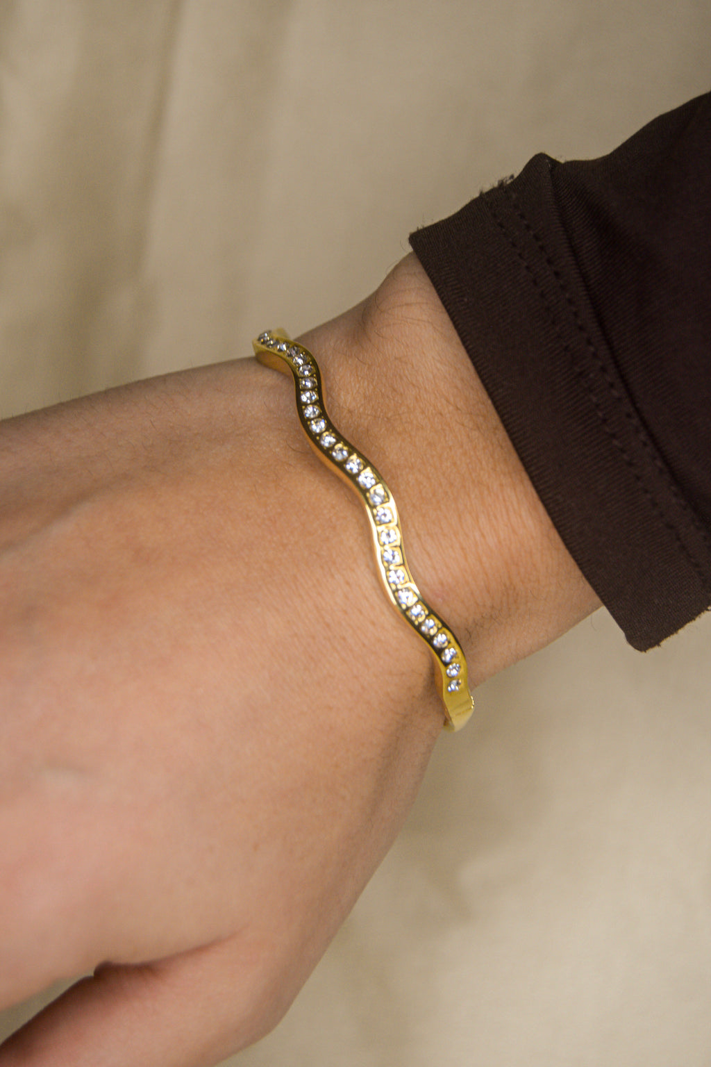 Pulseira dourada com ondas brilhantes