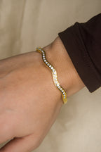 Pulseira dourada com ondas brilhantes