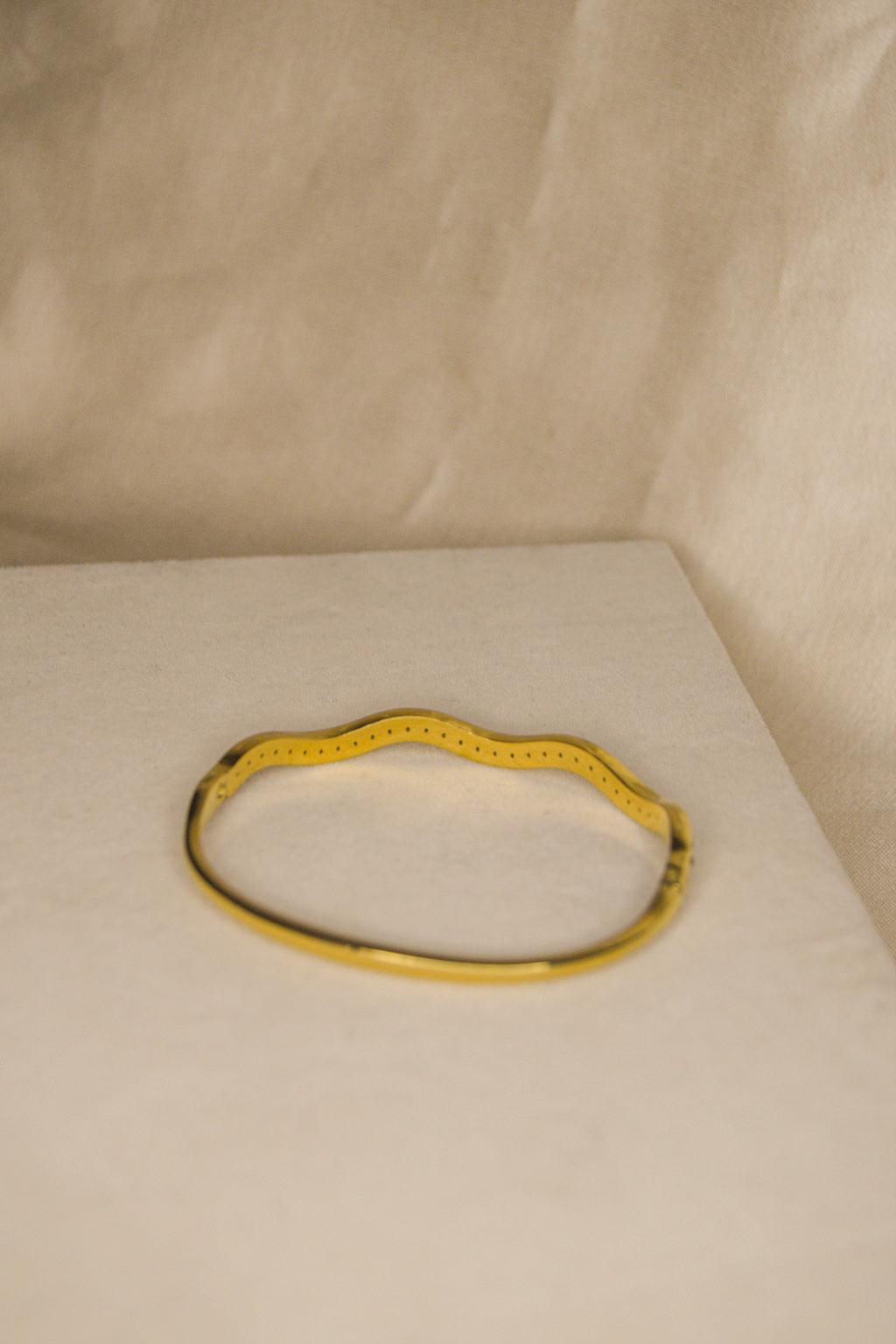 Pulseira dourada com ondas brilhantes