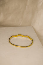 Pulseira dourada com ondas brilhantes