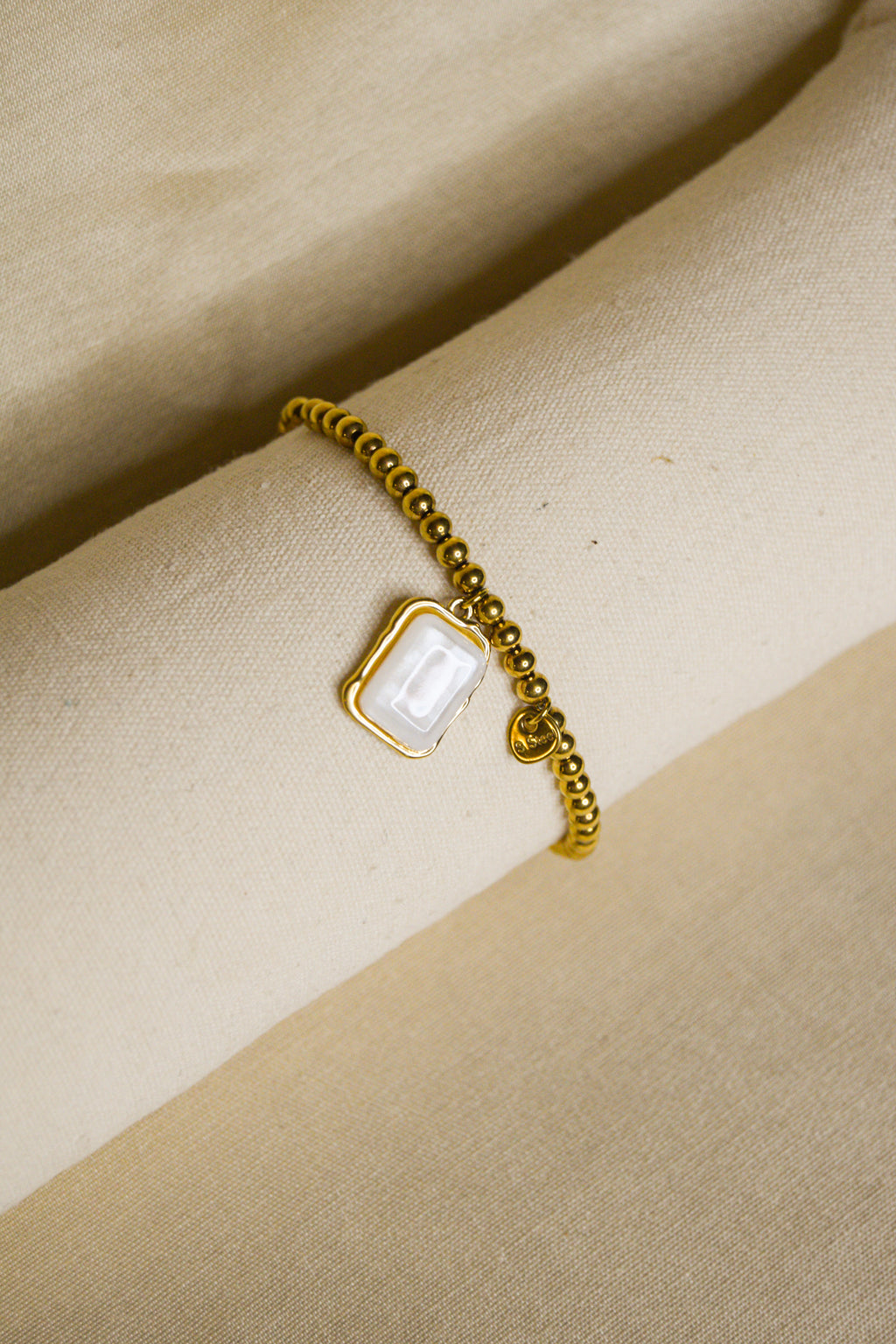 Pulseira dourada pendente pérola