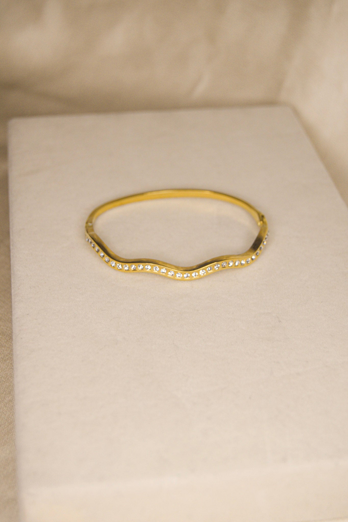 Pulseira dourada com ondas brilhantes