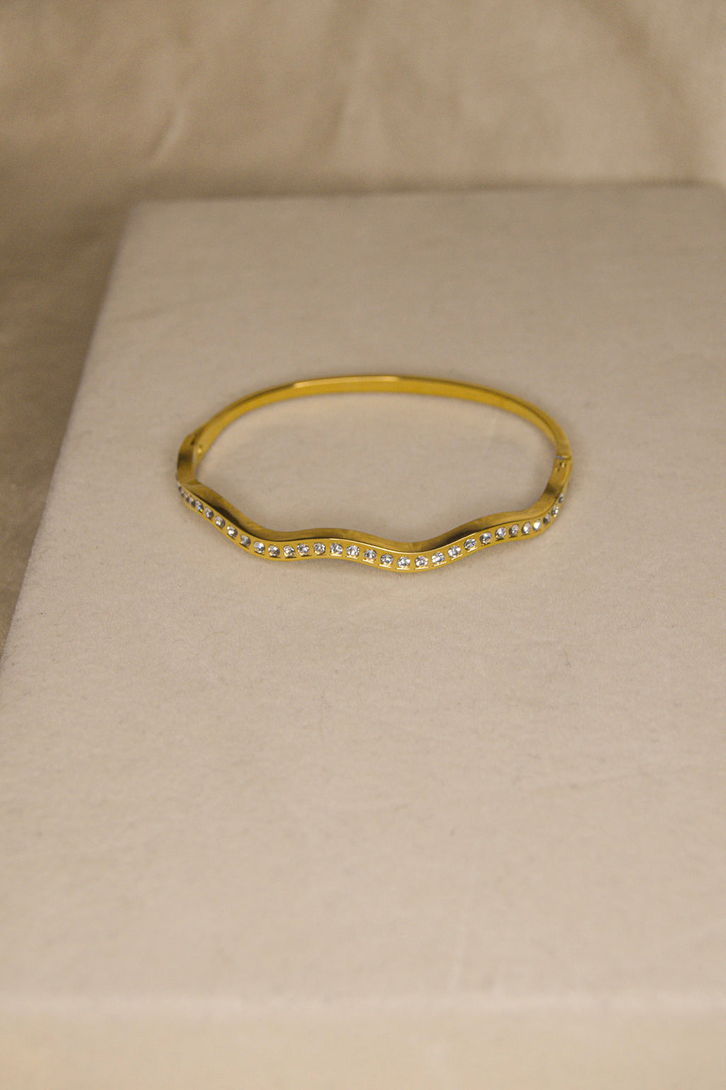 Pulseira dourada com ondas brilhantes