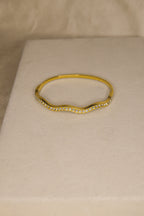 Pulseira dourada com ondas brilhantes