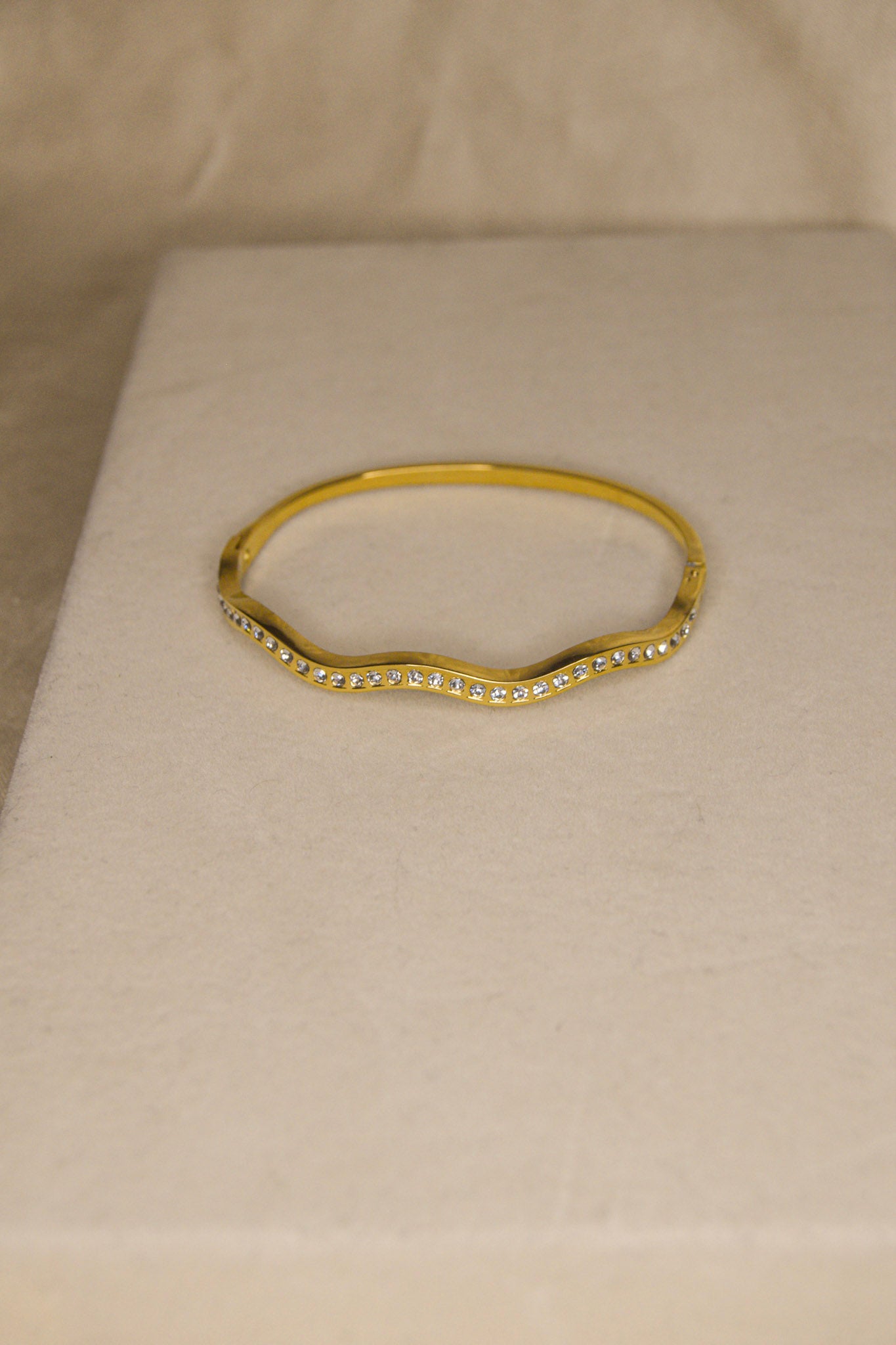 Pulseira dourada com ondas brilhantes