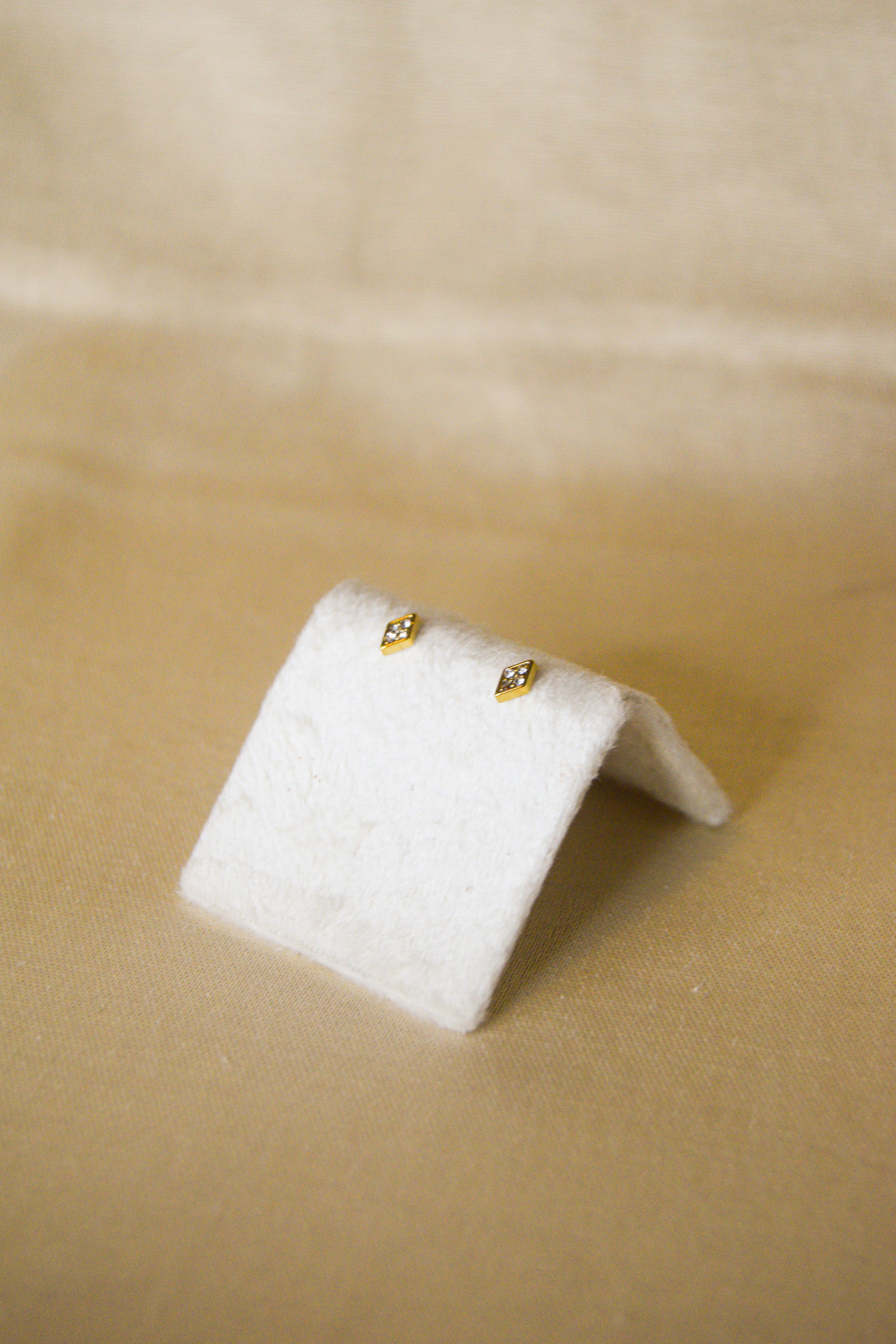 Piercing dourado losango