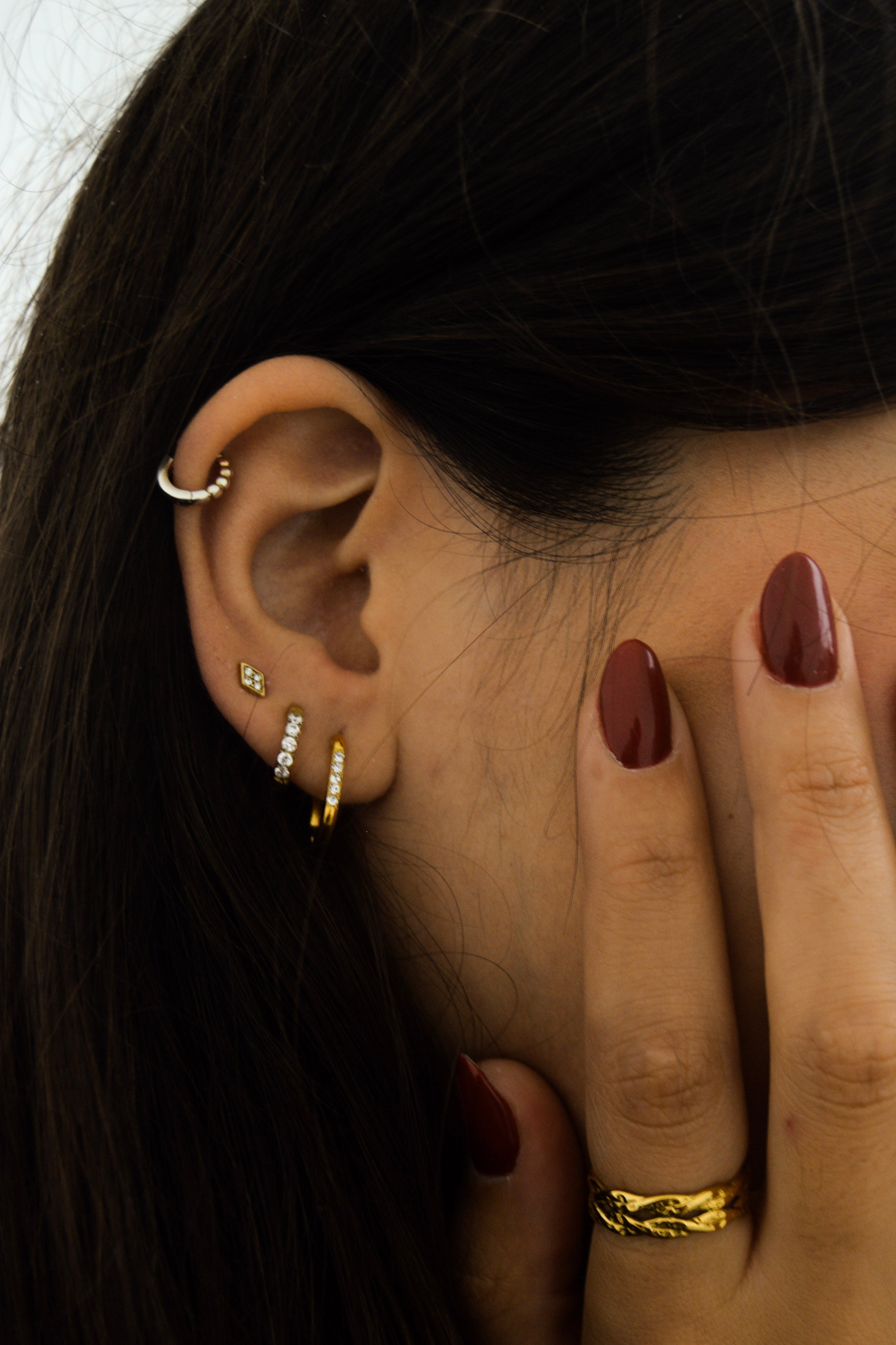 Piercing dourado losango